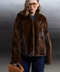 Model in a stylish brown mink fur coat with a short design, paired with denim and vintage-inspired sunglasses.