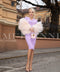 A woman wearing a sleek beige feather coat, perfect for layering over dresses to add an elegant and sophisticated touch.