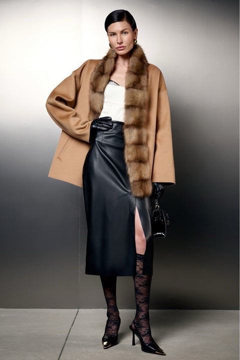 Short Camel Wool Coat with Mink Fur worn over a stylish black leather skirt for an elegant autumn look.
